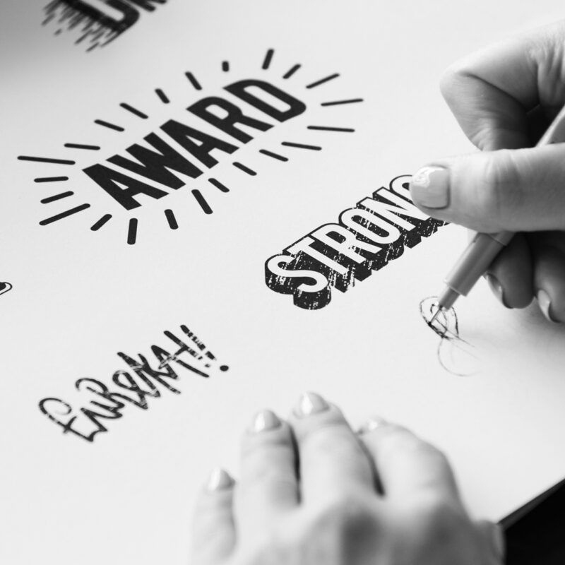 woman drawing word art and logo designs to create a strong brand for a business client